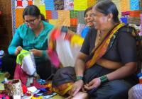 three women weaving colorful fabrics