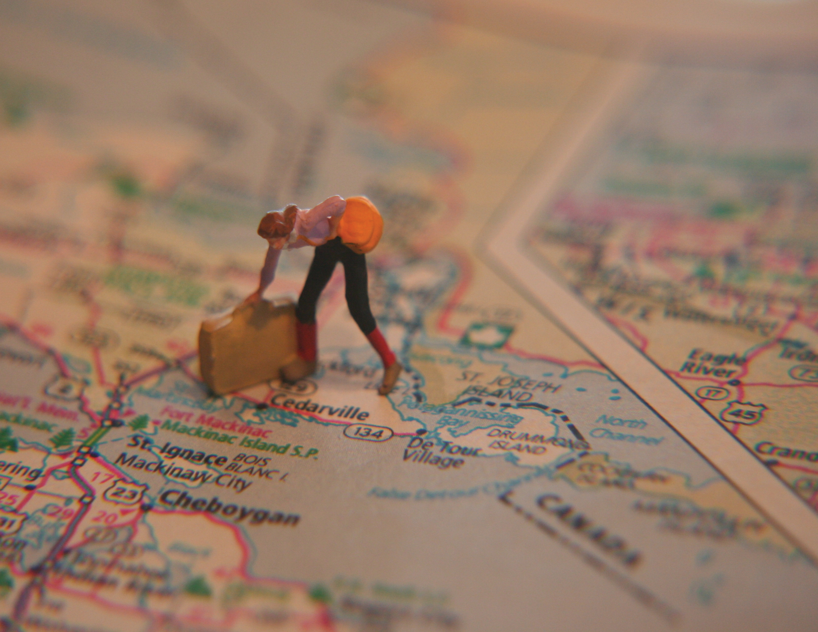 Neither Here Nor There Poster Image Figuring with briefcase standing on printed map