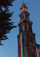 bicycle in front of Amsterdam Westerkerk church tower with rainbow flag banner