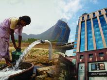 Woman collecting water fading into modern shops and skyscrapers
