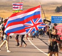 Girl waving large flag, symbolizing Hawaiian resistance to colonialism
