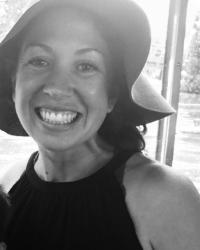 Profile Picture of Lydia Heberling. A black and white photo with Lydia wearing a soft brim sun hat and black sleeveless top. 