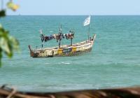 a solitary fishing boat on the ocean in Ghana